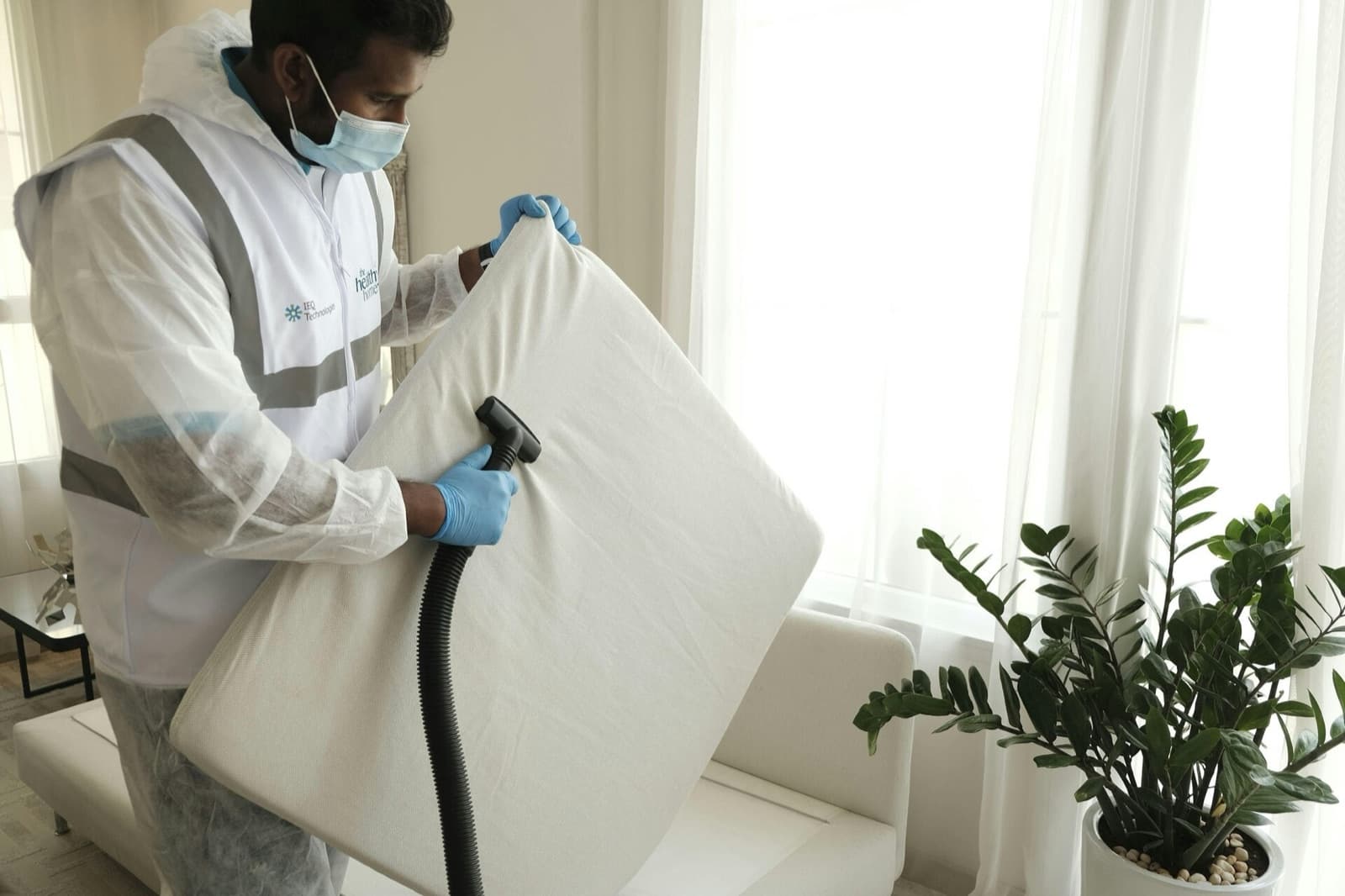 Technician steam sanitising a mattress